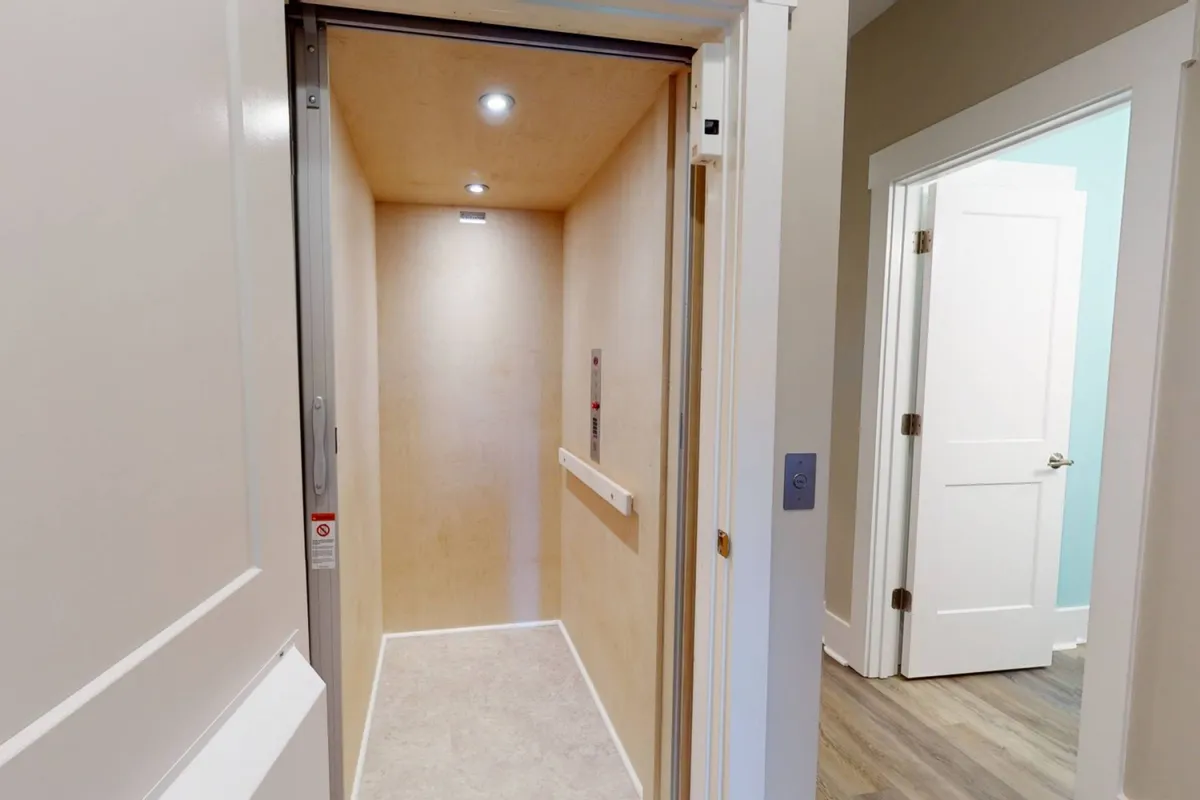 A modern elevator interior with a clean control panel and soft lighting, designed for easy access to all floors within the home. The space emphasizes accessibility for guests of all ages and ease of transporting luggage or supplies.